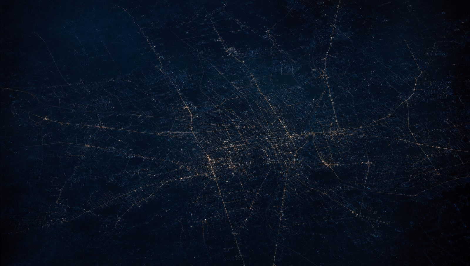 Aerial view of a city road grid glowing at night